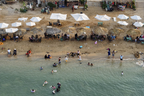 Foto udara orang-orang di pantai di kota Latakia, pesisir Mediterania Suriah, Rabu (11/6/2025). Foto: Omar Haj Kadour/AFP
