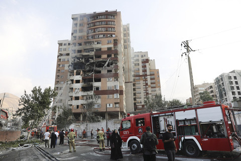 Petugas pemadam kebakaran bekerja di lokasi bangunan yang rusak setelah serangan Israel, di Teheran, Iran, Jumat (13/6/2025). Foto: Majid Asgaripour / WANA / via REUTERS