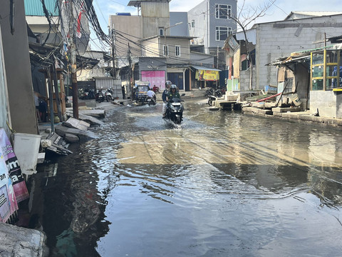 Genangan air setinggi mata kaki imbas banjir rob di Jalan Dermaga Ujung 2 Blok Empang, Muara Angke, Jakarta Utara, Jumat (13/6/2025). Foto: Nasywa Athifah/kumparan