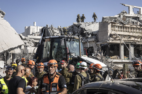 Petugas tanggap darurat melakukan pemeriksaan usai serangan Iran di salah satu perumahan di Tel Aviv, Israel, Sabtu (14/6/2025). Foto: John Wessels/AFP