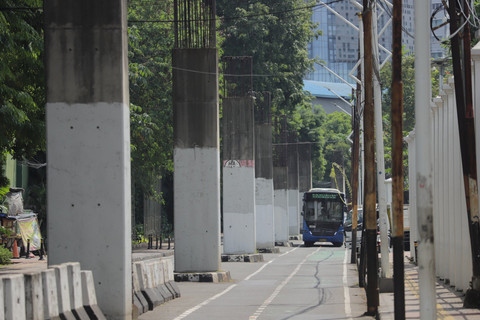 Bus TransJakarta melintas di dekat tiang bekas proyek monorel Jakarta di kawasan Jalan Asia Afrika, Jakarta Pusat, Minggu (15/6/2025). Foto: Jamal Ramadhan/kumparan