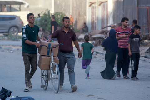 Warga Palestina yang mengungsi mengangkut paket bantuan kemanusiaan di sebelah barat Jabalia, Jalur Gaza utara, Senin (16/6/2025). Foto: Bashar Taleb / AFP