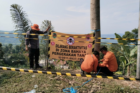 Petugas memasang rambu dan imbauan kawasan zona berbahaya di lokasi pergerakan tanah di Desa Pasirmunjul, Kecamatan Sukatani, Kabupaten Purwakarta, Jawa Barat, pada Sabtu (14/6/2025). Foto: BPBD Kabupaten Purwakarta