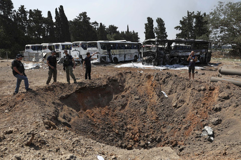 Polisi berdiri di samping kawah di lokasi benturan setelah serangan rudal dari Iran, di Herzliya, Israel, Selasa (17/6/2025). Foto: Ronen Zvulun/REUTERS