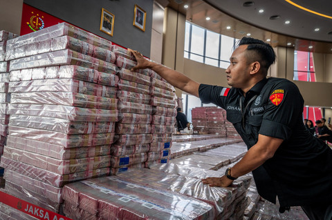 Petugas merapikan barang bukti uang sitaan saat konferensi pers kasus korupsi ekspor crude palm oil (CPO) di Gedung Bundar Jampidsus Kejaksaaan Agung (Kejagung), Jakarta, Selasa (17/6/2025). Foto: Bayu Pratama S/ANTARA FOTO