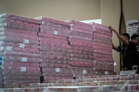 Petugas merapikan barang bukti uang sitaan saat konferensi pers kasus korupsi ekspor crude palm oil (CPO) di Gedung Bundar Jampidsus Kejaksaaan Agung (Kejagung), Jakarta, Selasa (17/6/2025). Foto: Bayu Pratama S/ANTARA FOTO