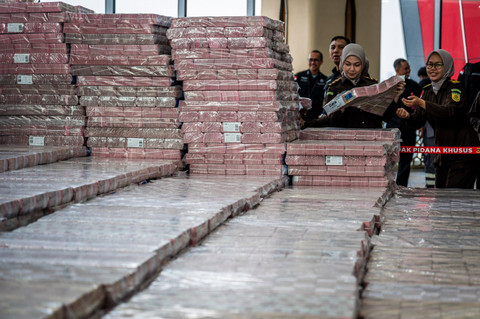 Petugas merapikan barang bukti uang sitaan saat konferensi pers kasus korupsi ekspor crude palm oil (CPO) di Gedung Bundar Jampidsus Kejaksaaan Agung (Kejagung), Jakarta, Selasa (17/6/2025). Foto: Bayu Pratama S/ANTARA FOTO