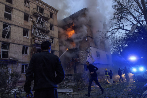 Sejumlah petugas memadamkan api yang membakar bangunan akibat serangan Rusia di Kyiv, Ukraina, Selasa (17/6/2025). Foto: Thomas Peter/Reuters