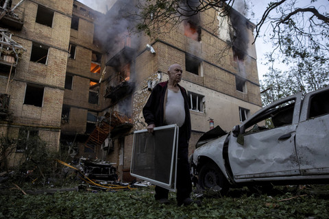 Warga membawa barang saat berjalan keluar dari bangunan yang rusak akibat serangan Rusia di Kyiv, Ukraina, Selasa (17/6/2025). Foto: Thomas Peter/Reuters