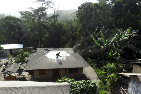 Warga Desa Hikong membersihkan atap rumahnya dari abu dampak erupsi Gunung Lewotobi Laki-laki di Kecamatan Talibura, Kabupaten Sikka, NTT, Rabu (18/6/2025). Foto: Gregorio J Gilbert/ANTARA FOTO