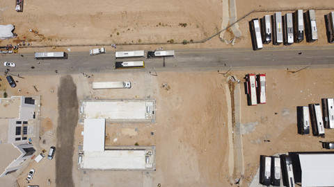 Foto udara sejumlah bus yang membawa jemaah haji asal Iran terpakir di perbatasan Arar antara Irak dan Arab Saudi, Selasa (17/6/2025). Foto: Ahmed Saad/Reuters