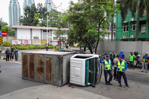 Sebuah kendaraan pengangkut kiriman terbalik usai menabrak pembatas jalan di kawasan Kuningan, Jakarta, Rabu (19/6/2025). Foto: Iqbal Firdaus/kumparan