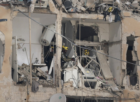 Petugas darurat bekerja di dalam gedung yang rusak di lokasi dampak setelah serangan rudal dari Iran ke Israel, di Ramat Gan, Israel, Kamis (19/6/2025). Foto: Ammar Awad/REUTERS