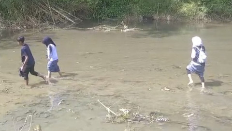 Momen pelajar di desa di Cianjur menyeberangi Sungai Cisokan untuk bersekolah. Foto: Istimewa
