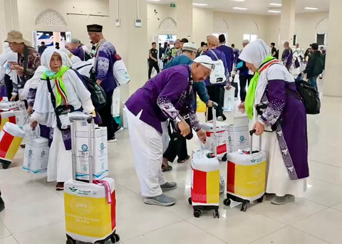 Jemaah haji Kloter 7 Kabupaten Bandung saat mengambil koper di Debarkasi Kertajati Indramayu. (20/6/2025). Foto: Panji Asmara/kumparan