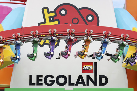 Sejumlah pengunjung menaiki wahana roller-coaster saat berwisata di LEGOLAND Shanghai Resort, Shanghai, China, Jumat (20/6/2025). Foto: Go Nakamura/REUTERS