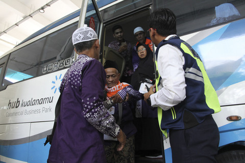 Jemaah haji penumpang pesawat Saudia Airlines SVA5688 berjalan menuju bus untuk dipindahkan ke hotel di Bandara Kualanamu, Sabtu (21/6/2025). Foto: Yudi Manar/ ANTARA FOTO