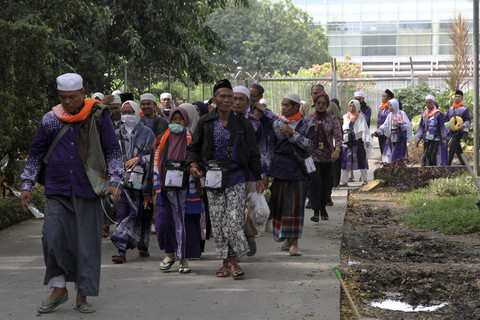 Jamaah haji pesawat Saudia Airlines SV-5688 berjalan menuju bus untuk dipindahkan ke hotel di Bandara Internasional Kualanamu, Kabupeten Deli Serdang, Sumatera Utara, Sabtu  (21/6/2025). Foto: Yudi Manar/ ANTARA FOTO
