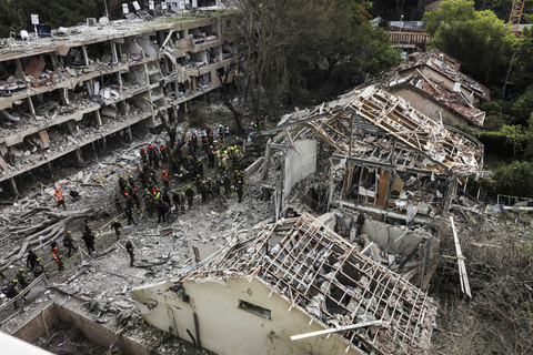 Petugas penyelamat dan petugas keamanan bekerja di lokasi yang terkena dampak setelah serangan rudal dari Iran, di tengah konflik Iran-Israel di Tel Aviv, Israel, Minggu (22/6/2025). Foto: Tomer Appelbaum/REUTERS