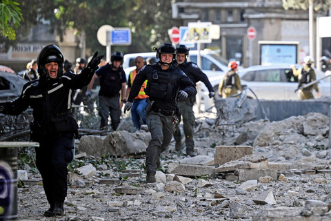 Tim penyelamat bekerja di lokasi bangunan yang hancur setelah serangan rudal dari Iran di Haifa, Israel, Minggu (22/6/2025). Foto: Florion Goga/REUTERS