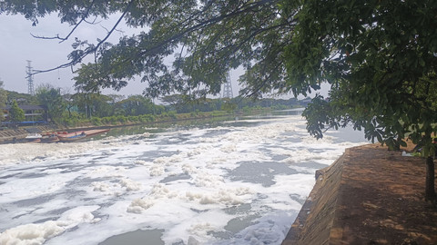 Gumpalan busa putih di kali BKT setelah keluar dari pintu air Wier 3 Marunda menuju Jembatan Pangkalan, Jakarta Utara, Senin (23/6/2025). Foto: Thomas Bosco/kumparan