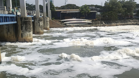 Gumpalan busa putih di kali BKT setelah keluar dari pintu air Wier 3 Marunda menuju Jembatan Pangkalan, Jakarta Utara, Senin (23/6/2025). Foto: Thomas Bosco/kumparan