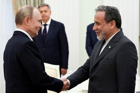 Presiden Rusia Vladimir Putin berjabat tangan dengan Menteri Luar Negeri Iran Abbas Araqchi di Kremlin, Moskow, Rusia, Senin (23/6/2025). Foto: Sputnik/Alexander Kazakov/Pool via REUTERS