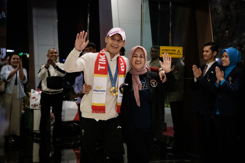 Atlet angkat besi Indonesia, Rizki Juniansyah, bersama ibu kandungnya. Foto: Yasuyoshi CHIBA / AFP