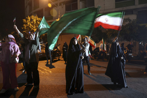 Sejumlah warga Iran mengibarkan bendera saat merayakan serangan Iran ke pangakalan Militer Amerika Serikat (AS) di Qatar di Teheran, Iran, Senin (23/6/2025). Foto: WANA (West Asia News Agency) via REUTERS