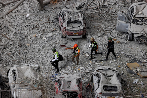 Petugas tanggap darurat melihat kondisi permukiman yang terkena dampak serangan rudal dari Iran di Be'er Sheva, Israel, Selasa (24/6/2025). Foto: Amir Cohen/REUTERS