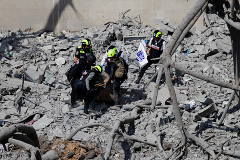 Petugas tanggap darurat melihat kondisi permukiman yang terkena dampak serangan rudal dari Iran di Be'er Sheva, Israel, Selasa (24/6/2025). Foto: Amir Cohen/REUTERS