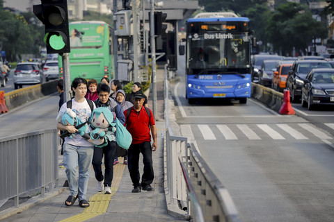 Sejumlah pegawai kantoran berjalan menuju halte bus Transjakarta di Halte Tosari, Jakarta, Selasa (24/6/2025). Foto: Jamal Ramadhan/kumparan