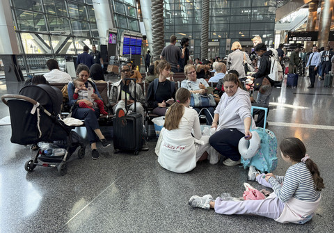 Sejumlah calon penumpang duduk menunggu keberangkatan di Bandara Internasional Hamad, Doha, Qatar, Selasa (24/6/2025). Foto: Stringer/Reuters