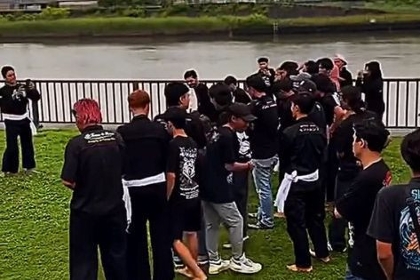 Pemuda Indonesia membentangkan spanduk besar bertuliskan "PSHT Madiun, Persaudaraan Setia Hati" di atas jembatan umum Jepang. Foto: Instagram/@unboxing.japan