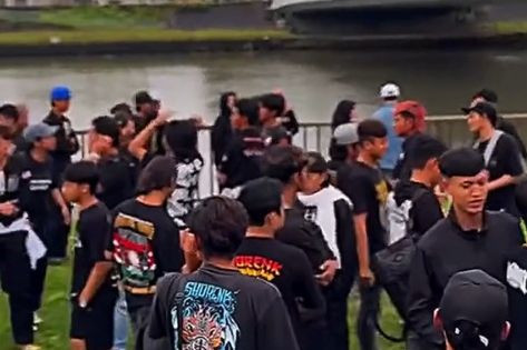 Pemuda Indonesia membentangkan spanduk besar bertuliskan "PSHT Madiun, Persaudaraan Setia Hati" di atas jembatan umum Jepang. Foto: Instagram/@unboxing.japan