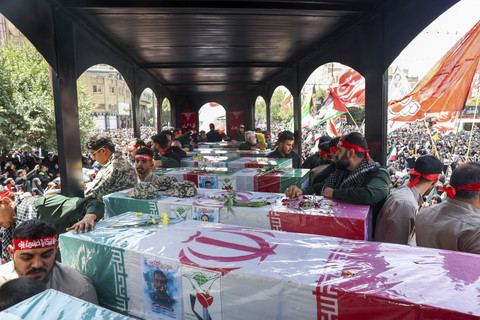 Dalam foto yang diperoleh dari kantor berita Iran ISNA ini, para pelayat berdiri di samping jenazah orang-orang yang terbunuh dalam serangan Israel di kota Mashhad, Jumat (27/6/2025). Foto: MOHAMMAD ALERASOOL/ISNA via AFP