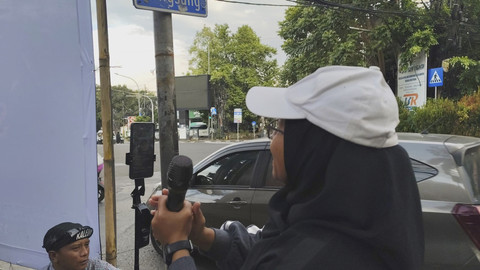 Ade Ariani (35) musisi jalanan di Simpang Dago yang terkenal melalui live TikTok, Senin (30/6/2025). Foto: Alya Zahra/kumparan