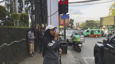 Ade Ariani (35) musisi jalanan di Simpang Dago yang terkenal melalui live TikTok, Senin (30/6/2025). Foto: Alya Zahra/kumparan