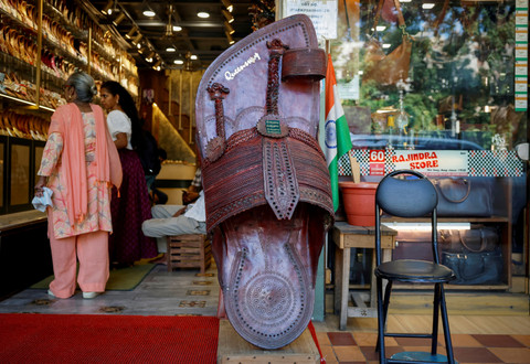Pelanggan berbelanja sandal 'Kolhapuri', alas kaki etnik India, di sebuah toko di New Delhi, India, Jumat (27/6/2025). Foto: Adnan Abidi/REUTERS