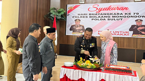 Pemotongan nasi tumpeng oleh Kapolres Bolmong dalam rangka HUT Bhayangkara, disaksikan Bupati dan Wakil Bupati Bolmong.