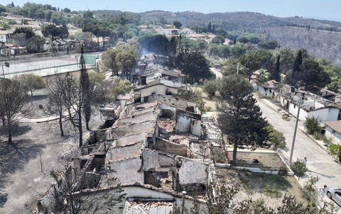 Foto yang diambil dari pesawat tanpa awak menunjukkan rumah-rumah yang hancur akibat kebakaran hutan di Seferihisar dekat Izmir, Turki, Senin (30/6/2025). Foto: Ufuk Erdem/REUTERS