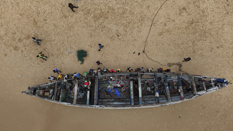 Foto udara sejumlah warga melihat kapal membawa migran dari Gambia dalam perjalanan ke Spanyol saat terdampar di Dakar, Senegal, Selasa (1/7/2025). Foto: Zohra Bensemra/Reuters