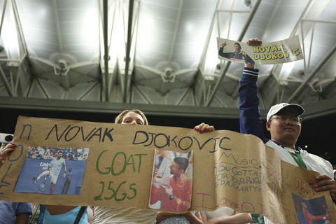 Dua penonton membentangkan poster saat pertandingan Tenis Wimbledon All England Lawn Tennis and Croquet Club di London, Inggris, Selasa (1/7/2025). Foto: Toby Melville/Reuters