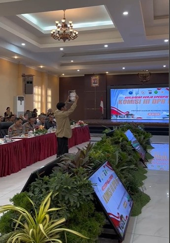 Ketua BEM KM UGM, Tiyo Ardianto, membentangkan poster #BebaskanKawanKami di hadapan Kapolda DIY dan anggota Komisi III DPR RI di Polda DIY, Rabu (2/7). Foto: Dok. BEM KM UGM
