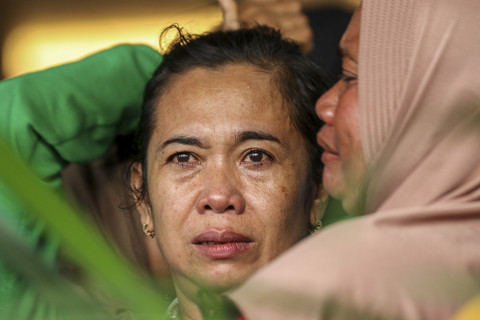 Keluarga korban menangis saat menanti kabar pencarian korban KMP Tunu Pratama Jaya yang tenggelam di Selat Bali di Posko pengaduan Pelabuhan Ketapang, Banyuwangi, Jawa Timur, Kamis (3/7/2025). Foto: Stringer/AFP