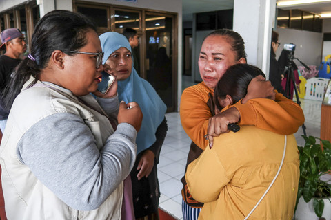 Keluarga korban menangis saat menanti kabar pencarian korban KMP Tunu Pratama Jaya yang tenggelam di Selat Bali di Posko pengaduan Pelabuhan Ketapang, Banyuwangi, Jawa Timur, Kamis (3/7/2025). Foto: Stringer/AFP