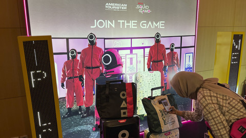 Pengunjung yang sedang melihat-lihat tas hingga koper American Tourister bertema serial Netflix Squid Game. Foto: Gitario Vista Inasis/kumparan
