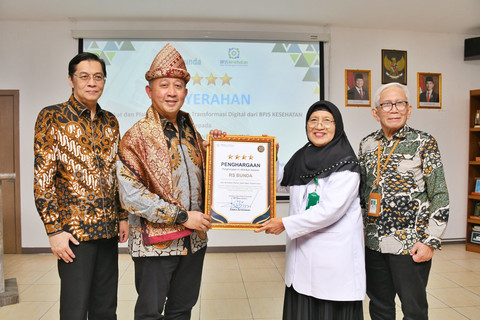 Direktur TI BPJS Kesehatan, Edwin Aristiawan, saat menyerahkan penghargaan kepada Direktur RS Bunda Palembang, dr.Hj.Halipah. (ist)