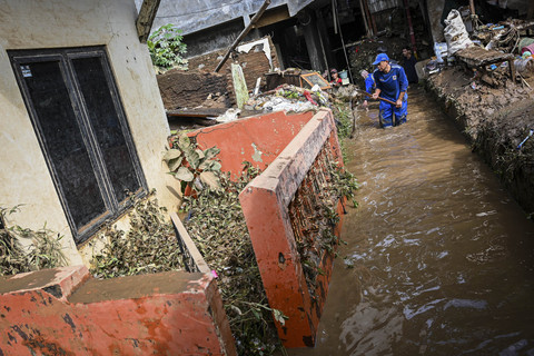 Petugas Dinas Sumber Daya Air membersihkan material banjir di kawasan permukiman di Kramat Jati, Cawang, Jakarta, Senin (7/7/2025). Foto: Sulthony Hasanuddin/ANTARA FOTO