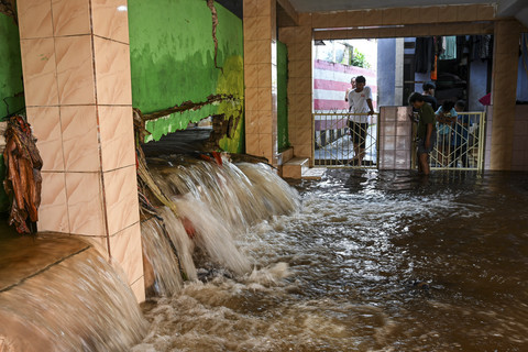 Warga melihat kondisi tembok musala yang jebol diterjang banjir di kawasan Kelurahan Jati Padang, Pasar Minggu, Jakarta, Senin (7/7/2025). Foto: Sulthony Hasanuddin/ANTARA FOTO